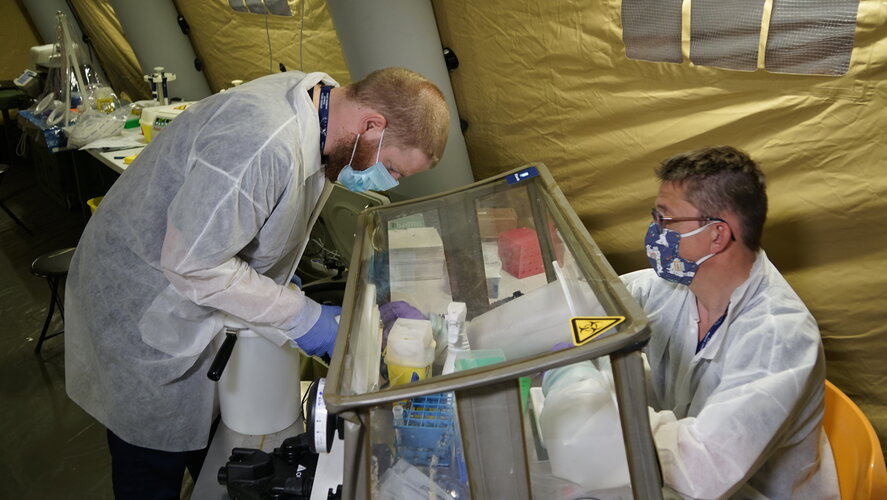 A sample is transferred for COVID-19 testing inside the mobile bio-lab in Piedmont