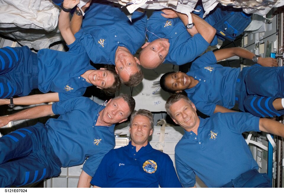 Thomas Reiter and the STS-121 crewmembers pose in "star-burst" formation for an in-flight portrait in the Destiny laboratory