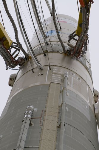 Various umbilical lines for power, fuel and communications are connected to an Ariane 5 rocket on the pad ready for launch