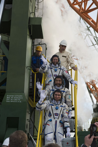 Soyuz TMA-18M crew members greeting audience at the launch pad