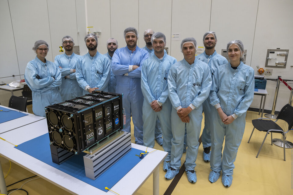 Fly Your Satellite teams 3Cat-4 and ISTSat-1 pose in front of their deployer at CSG