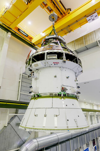 ESA and NASA logos are visible as the Artemis II Orion spacecraft is lifted into a vacuum chamber for testing